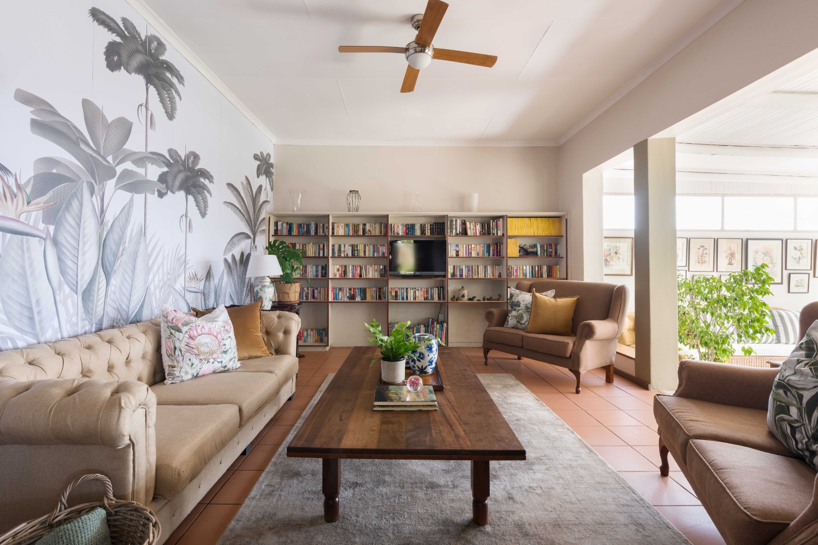 Library lounge with tropical mural and bookshelves